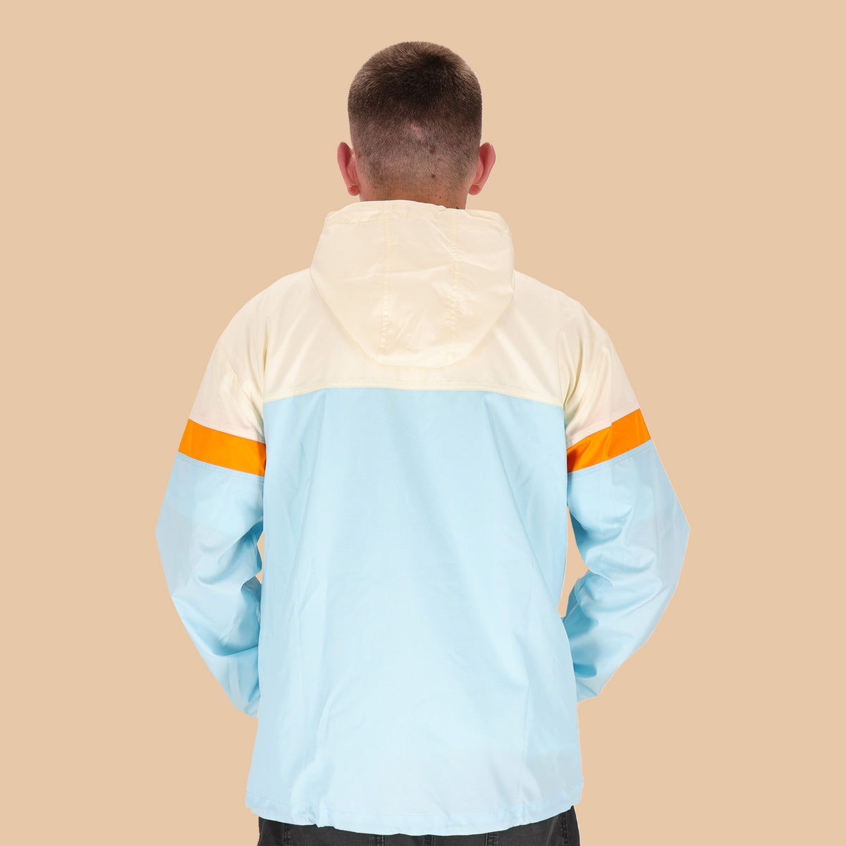 Veste coupe-vent Cavale & Godet à capuche, beige, orange et bleu.
