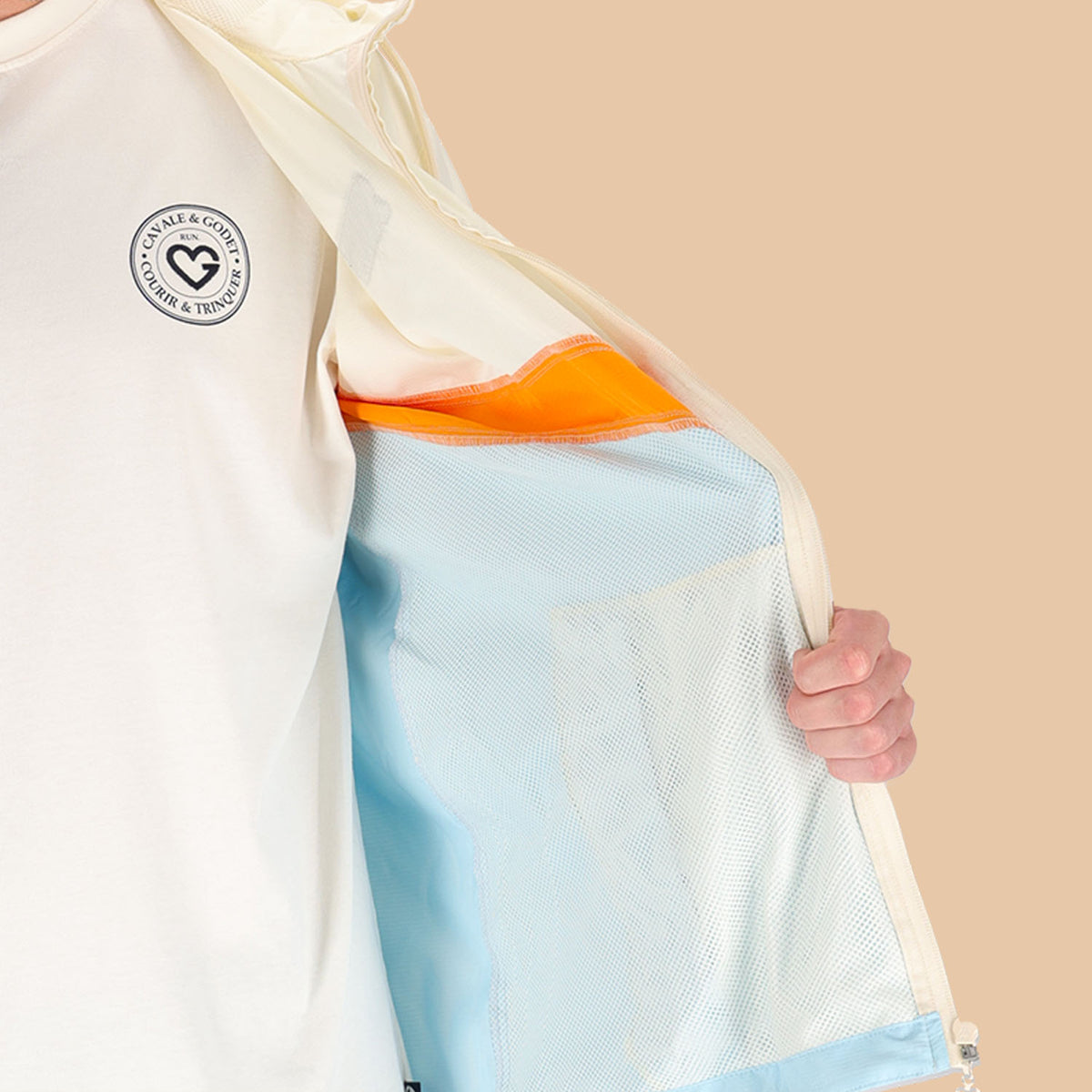 Veste coupe-vent Cavale & Godet à capuche, beige, orange et bleu.